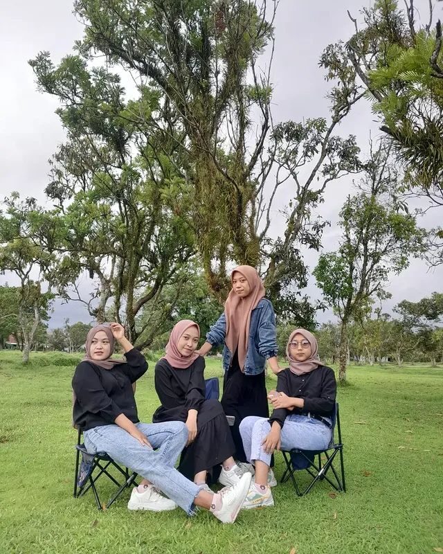 Empat orang berfoto bersama dengan kursi lipat di padang rumput dataran tinggi
